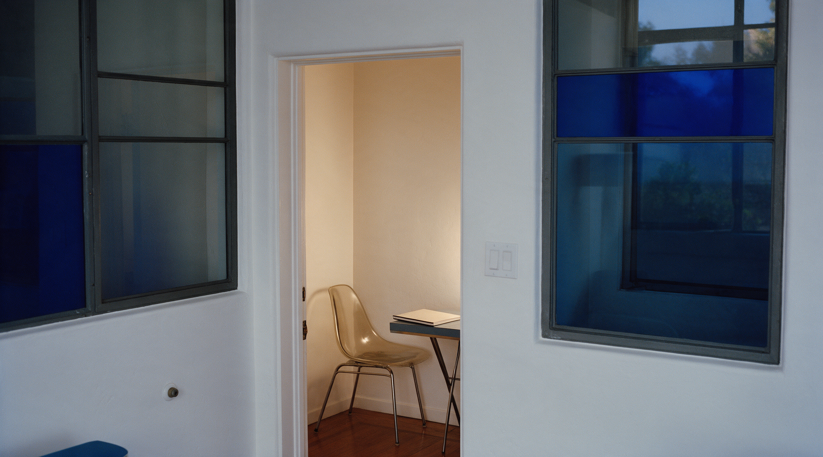 An open doorway into a quiet room with a notebook on a table